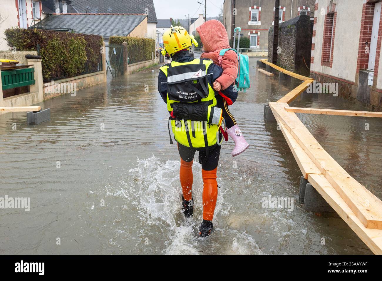 A rescue worker carries a child as severe flooding hits western France ...