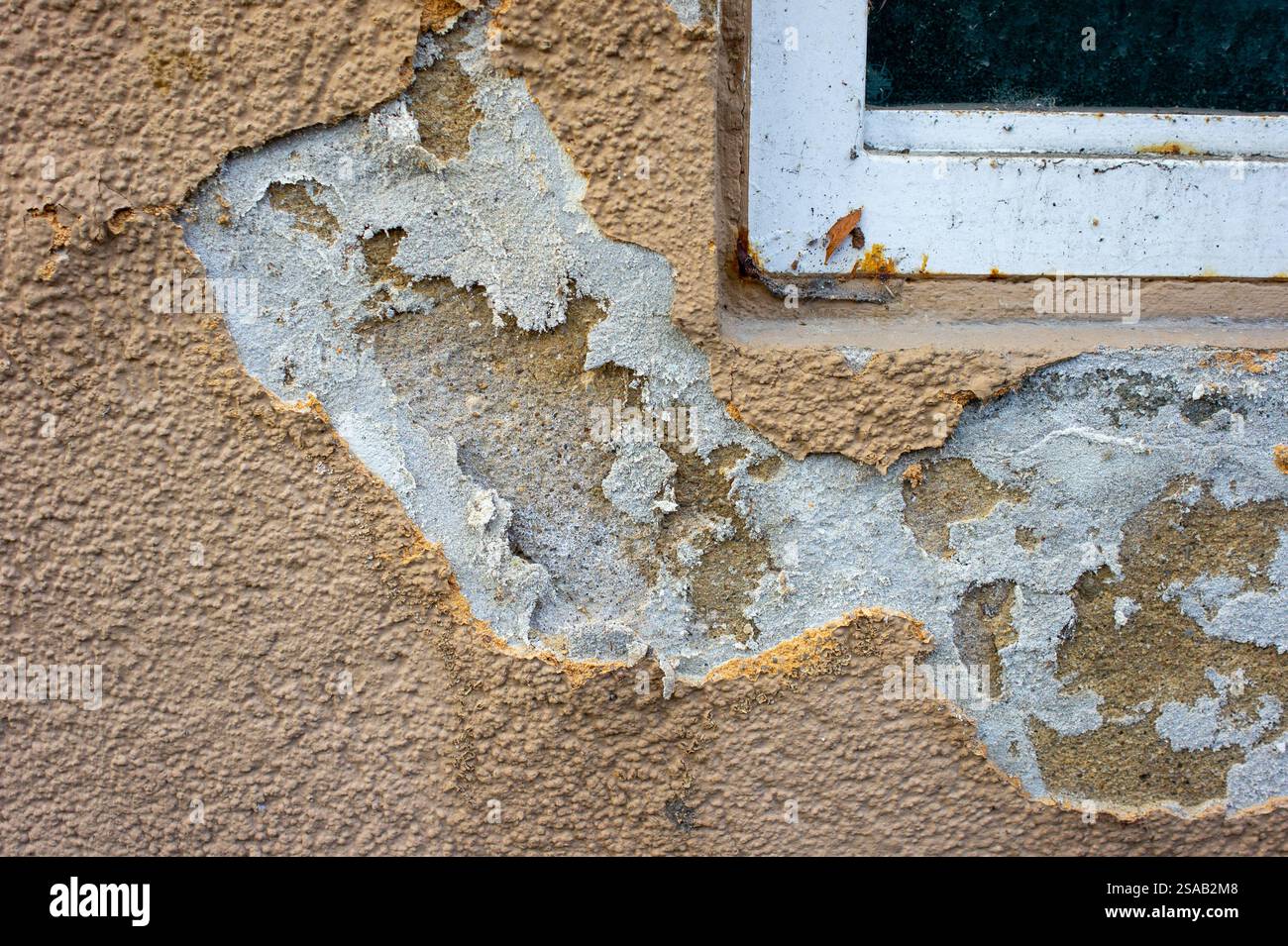 old wall with peeling paint and salpeter under the window Stock Photo