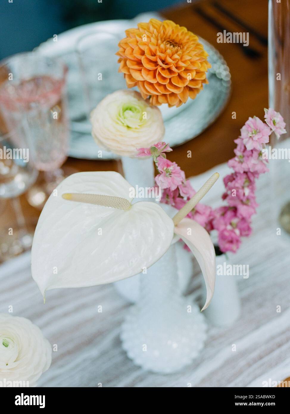A stunning floral centerpiece featuring orange zinnia, pink delphinium