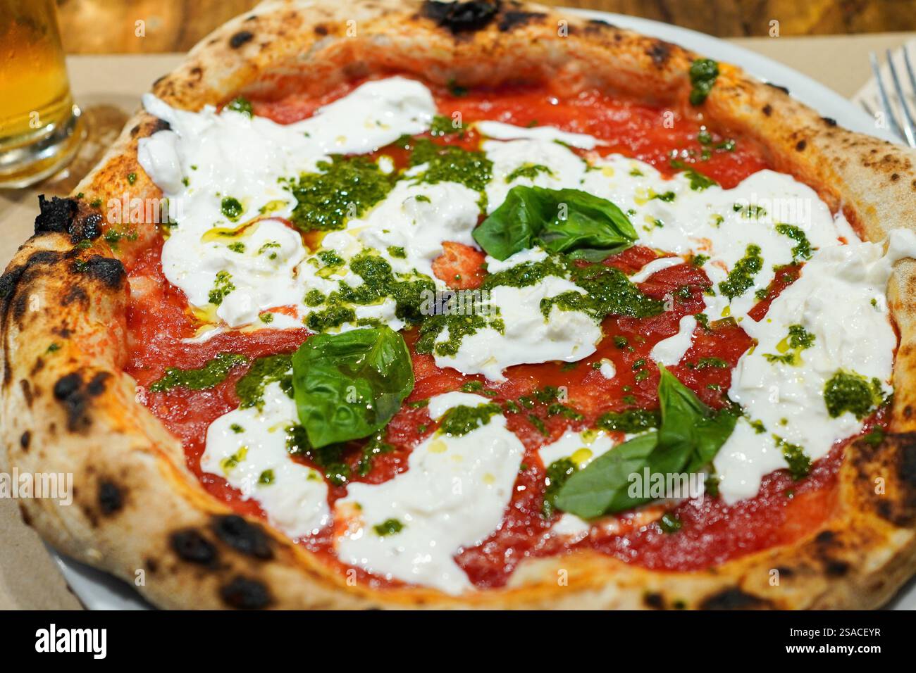 Delicious Italian pizza with burrata, fresh basil and pesto sauce Stock Photo