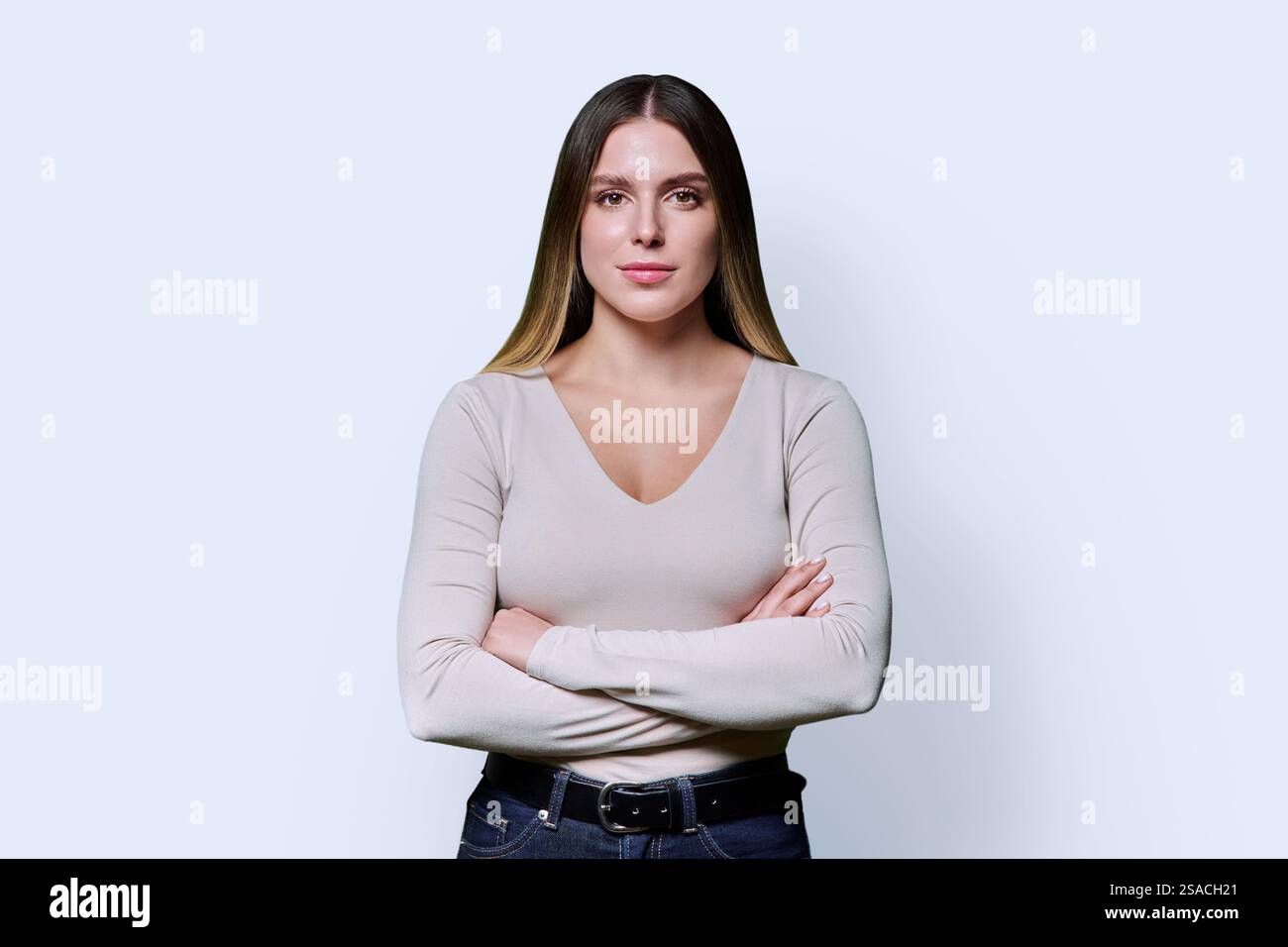 Portrait of young confident woman with crossed arms on white background ...
