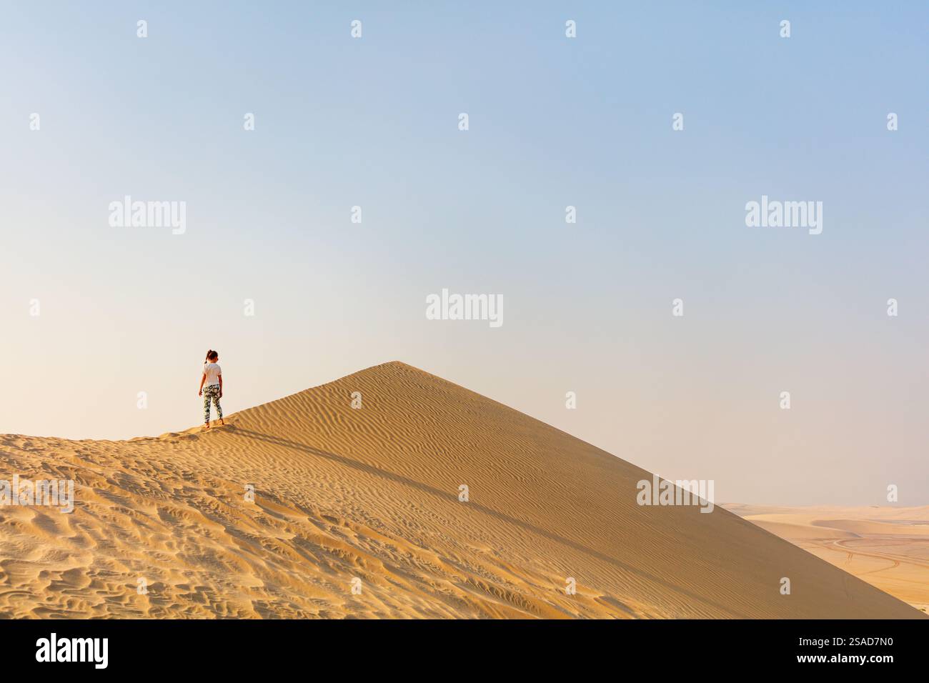 Little girl having fun playing at sand dunes in Qatar desert Stock ...