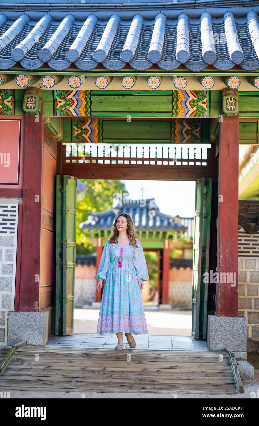 A woman wearing a flowing blue floral maxi dress poses beneath an ...