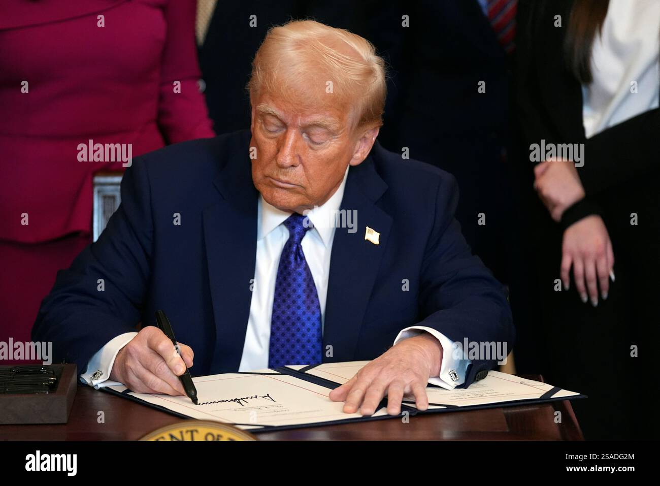 President Donald Trump signs the Laken Riley Act during an event in the ...