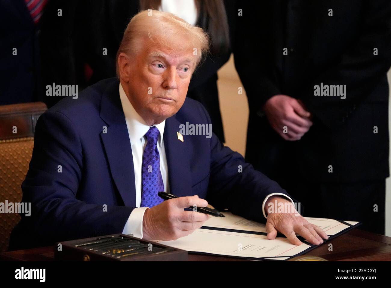 President Donald Trump signs the Laken Riley Act during an event in the ...