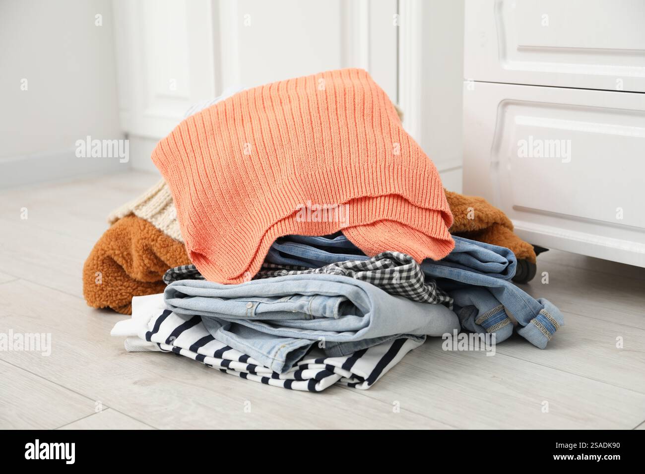 Pile of different used clothes on floor indoors Stock Photo - Alamy