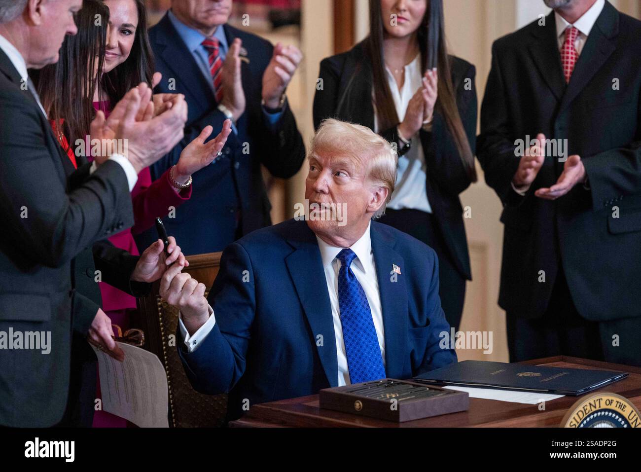US President Donald Trump hands out pens after signing the Laken Riley ...