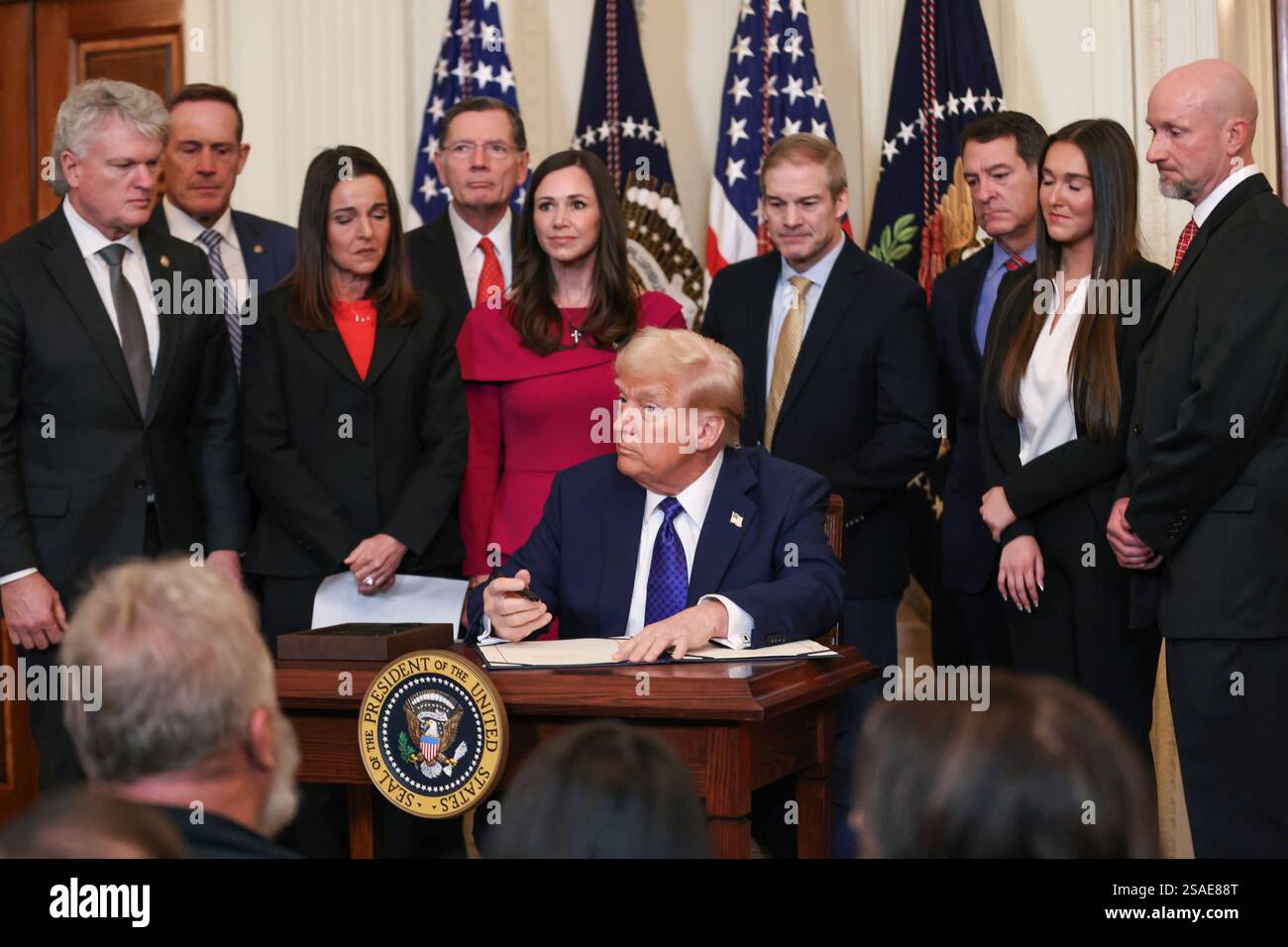 United States President Donald Trump signs the bill next to Laken Riley ...