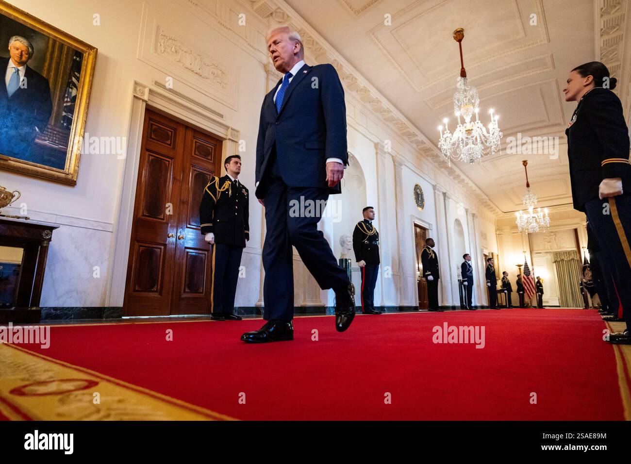 United States President Donald Trump walks along the cross hall towards ...