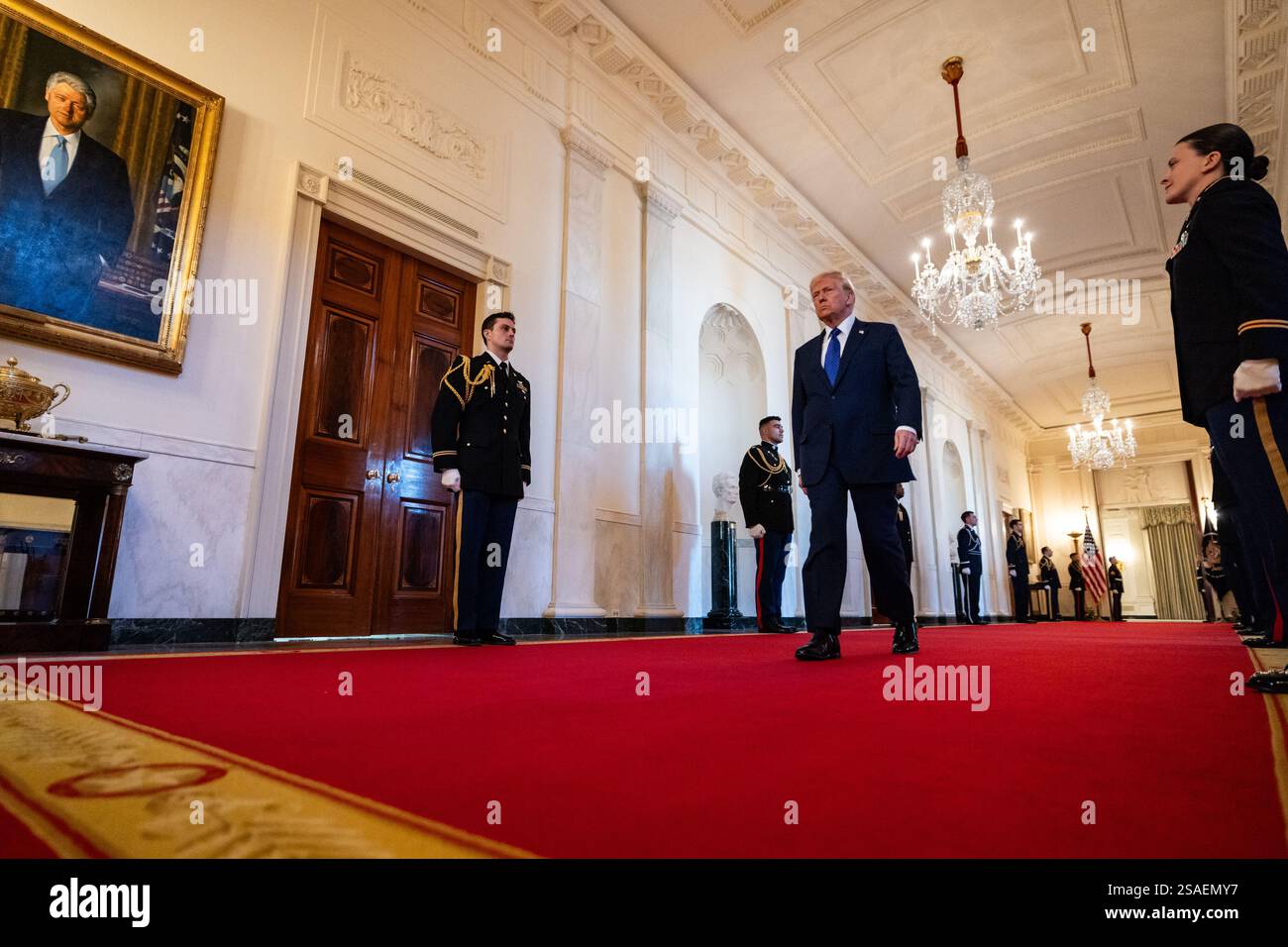 United States President Donald Trump walks along the cross hall towards ...