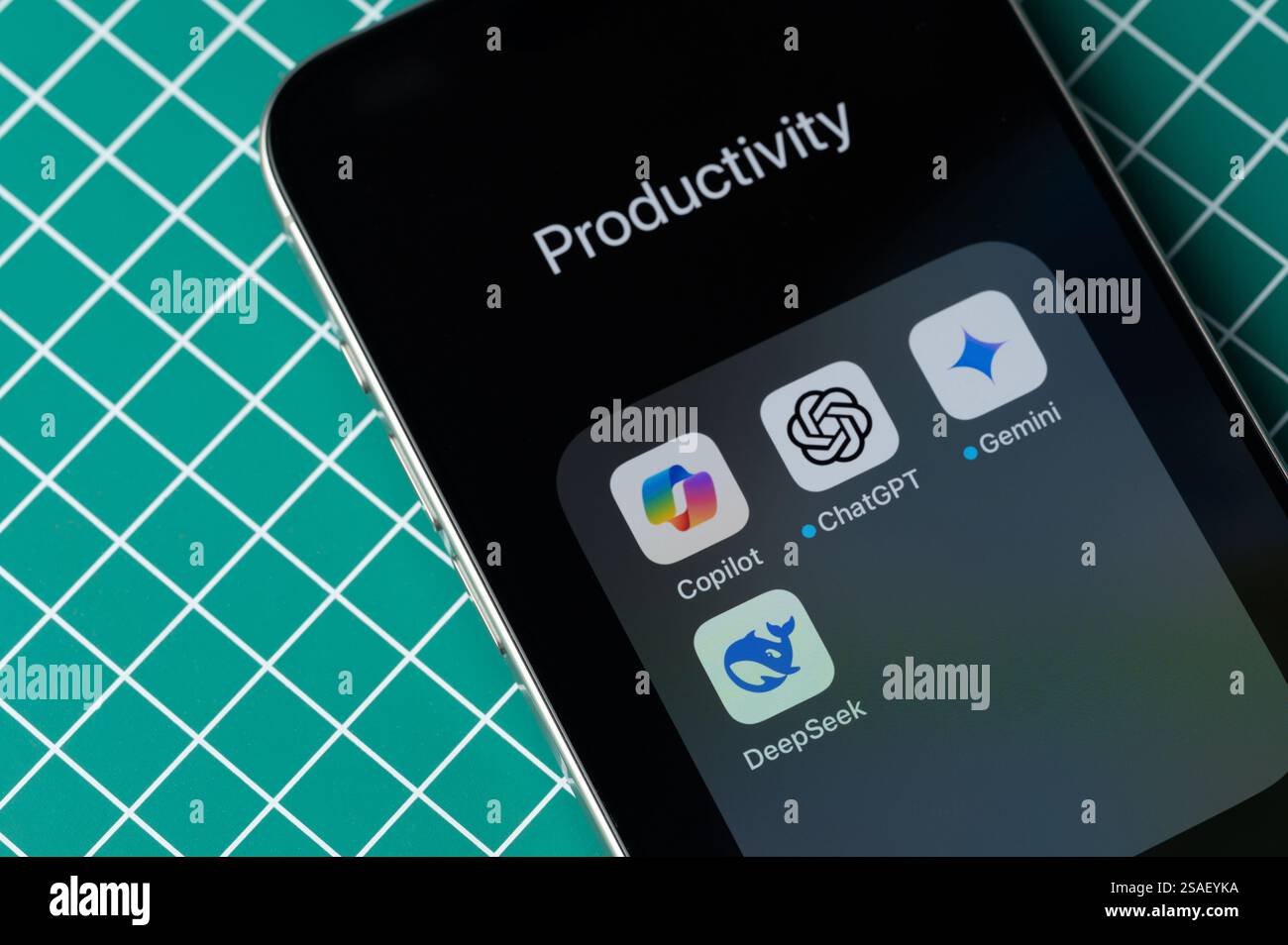 New York, USA - January 28, 2025: Set of AI Assistant on smartphone screen lay on DYI table close up view Stock Photo