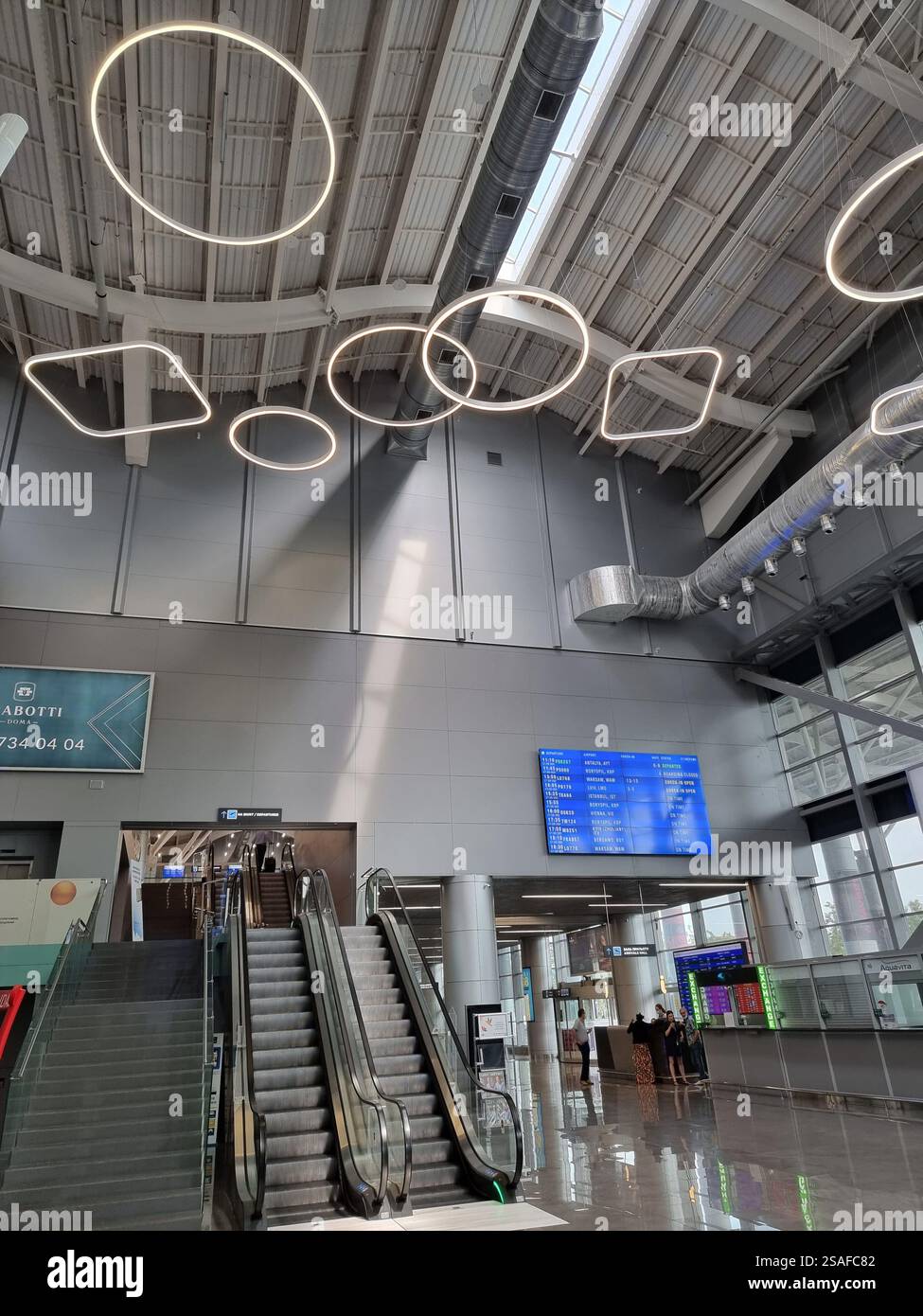 Interior of the new terminal of Odesa International airport (ODS / UKOO) in Ukraine with decorative lights at the ceiling - Smartphone Captured Stock Image