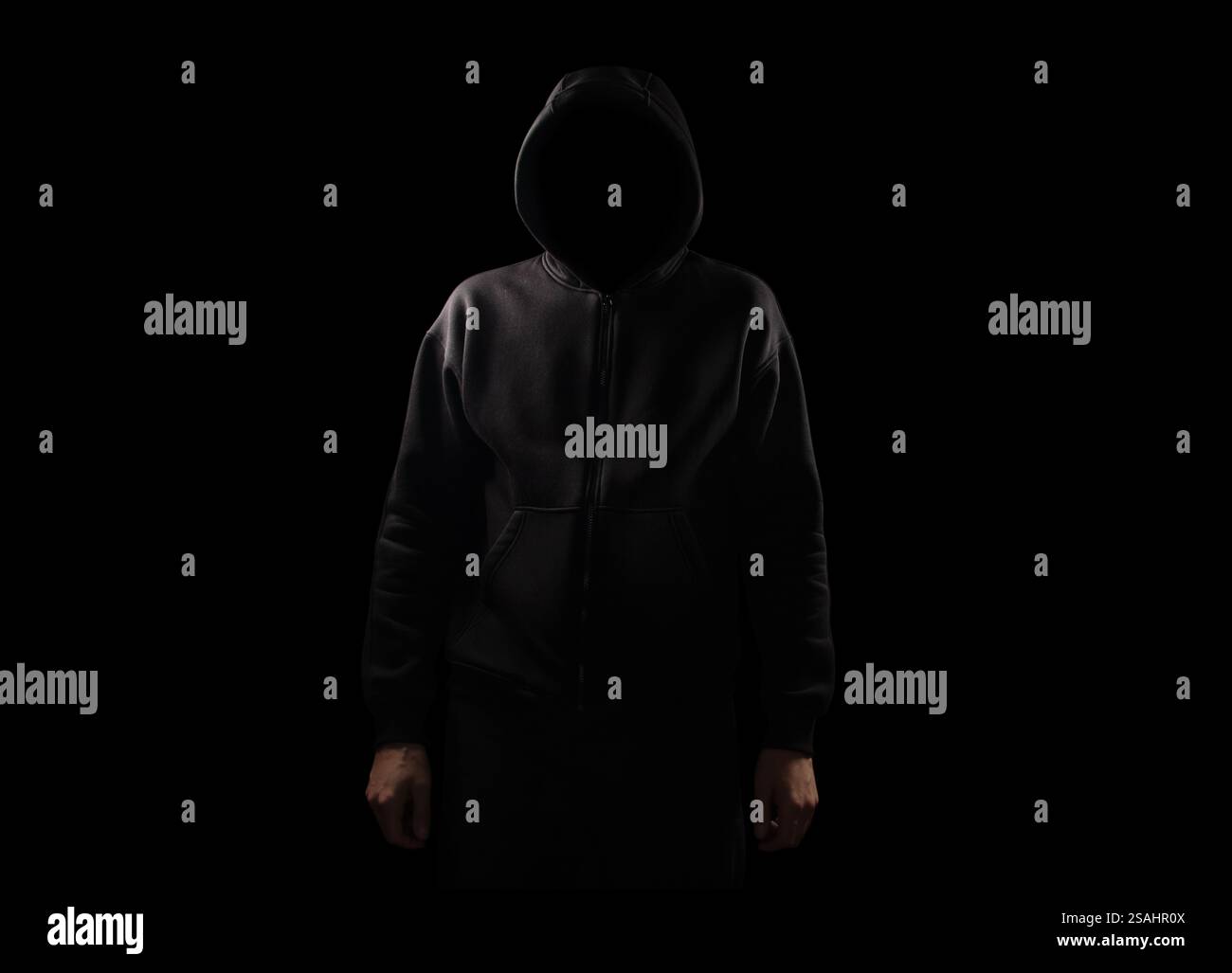 Silhouette of man in the hood or hooligan over dark background with ...