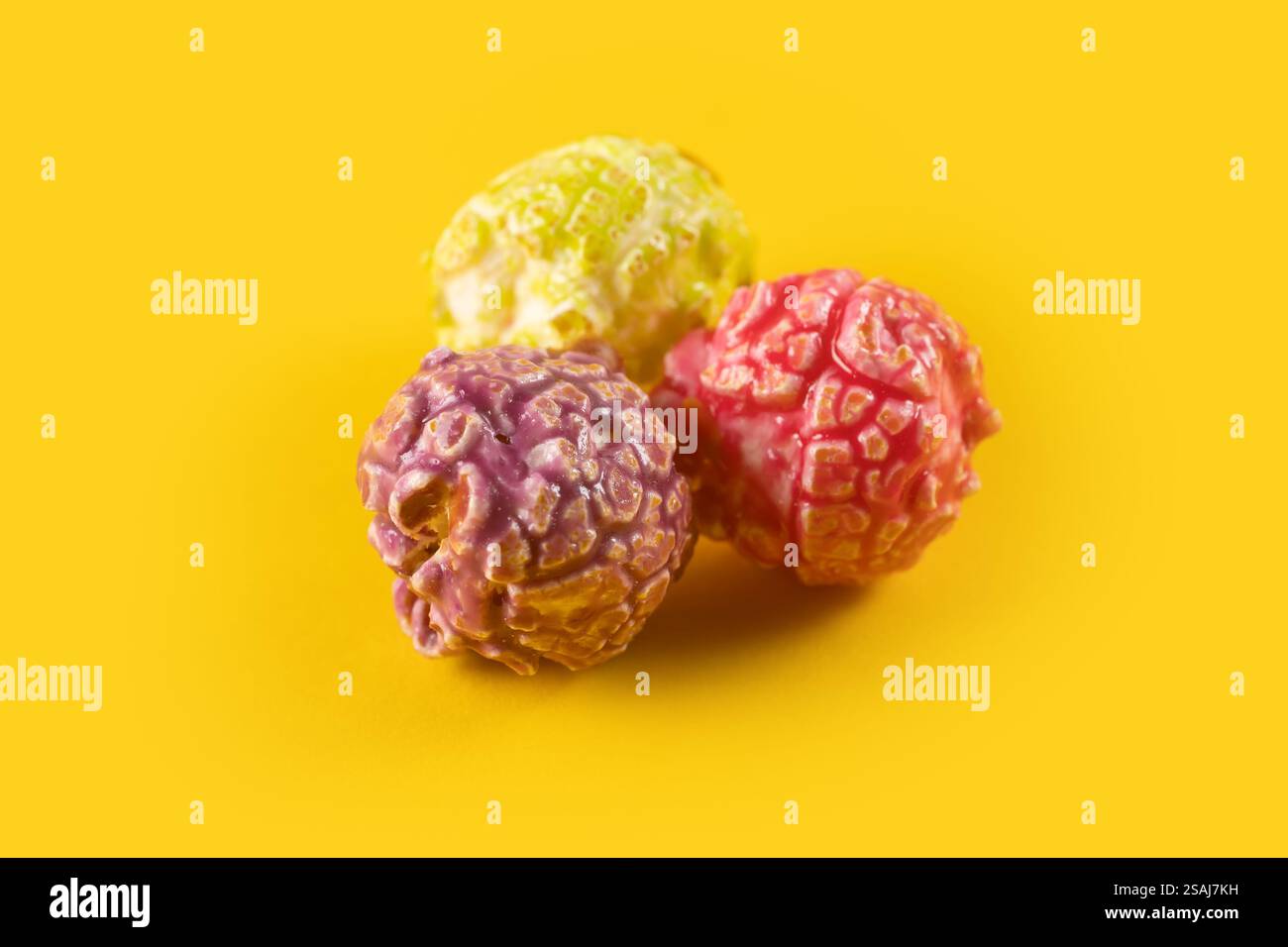 Colored fruity popcorn on yellow background. Stock Photo