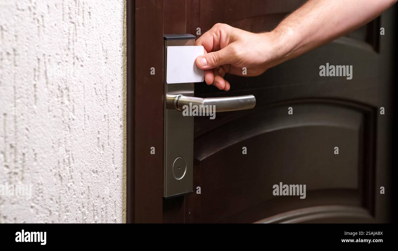 Male hand open hotel room door with electronic card key. key