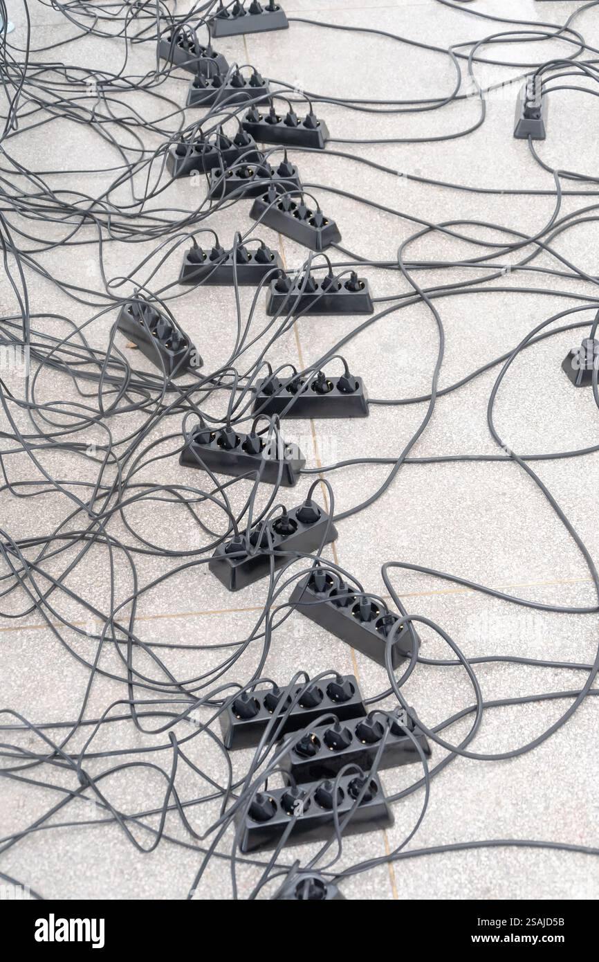 Chaotically arranged electrical cables and splitters. Stock Photo