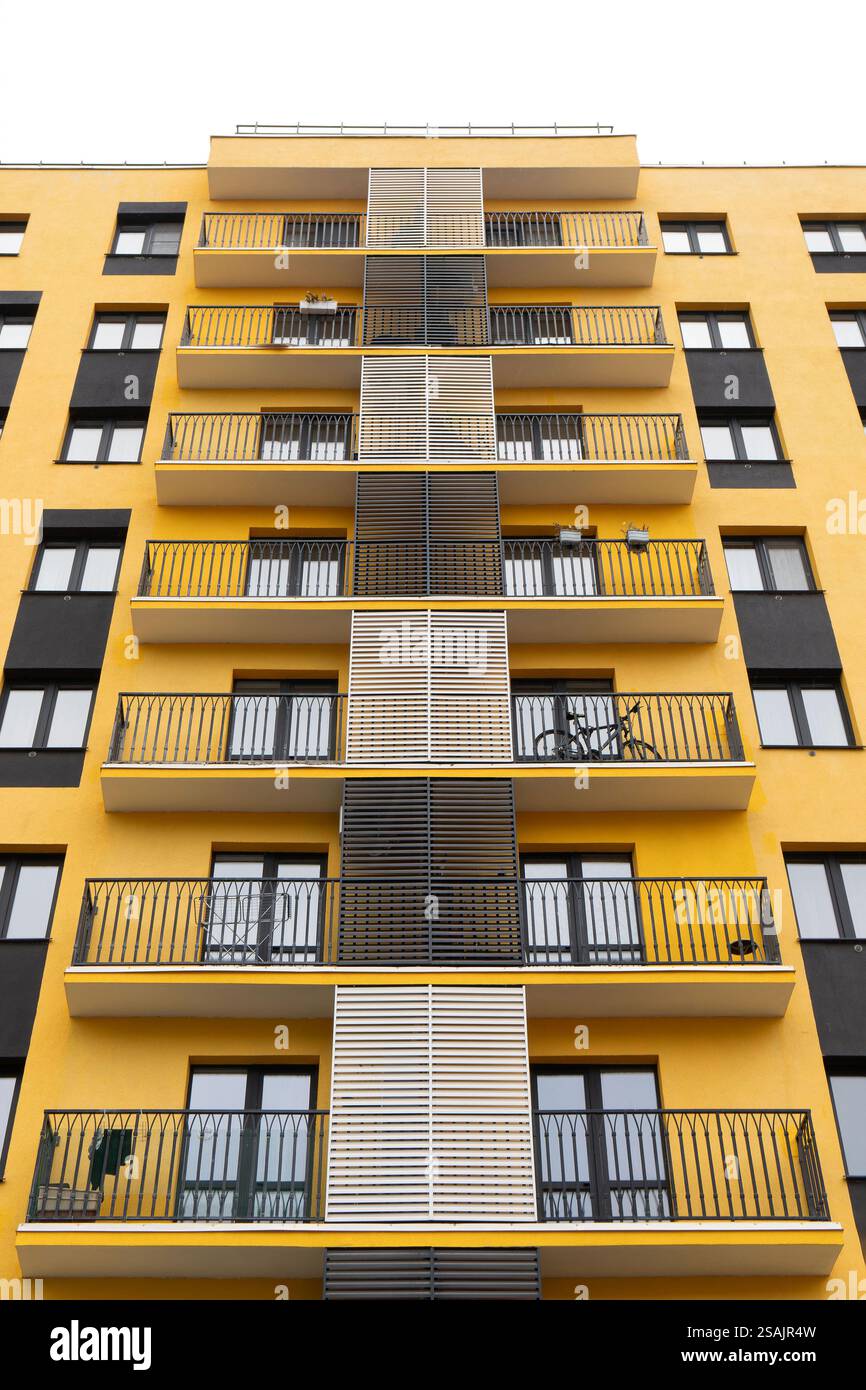 Modern apartment buildings with yellow facade, large windows, and ...