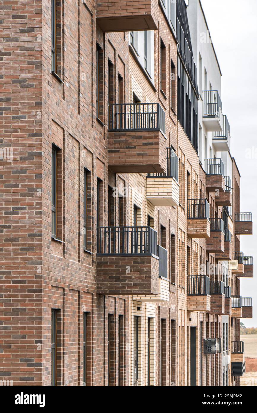 Modern brick building with multiple balconies with metal railings and ...
