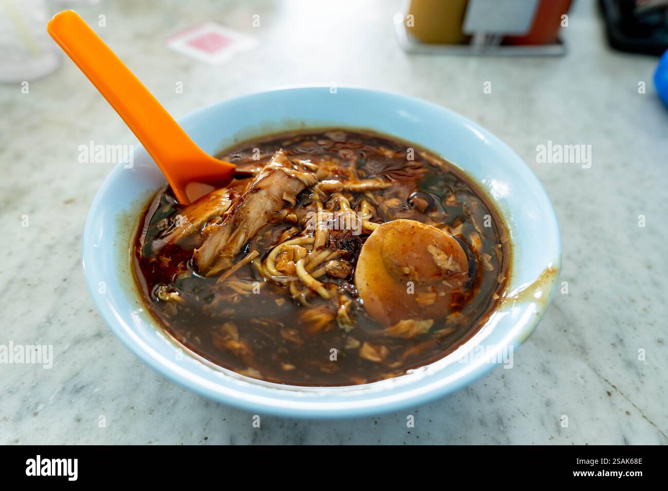 Close up of a bowl of  "lor mee" or noddles in thick soya sauce gravy. It is a hokkien noodle dish sold by hawkers and popular in Malaysia and Singapo Stock Photo