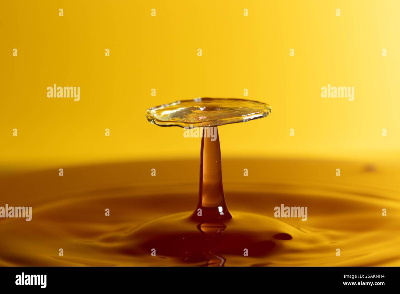 Splashart water collision on yellow background Stock Photo