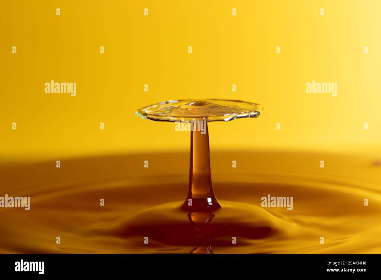 Splashart water collision on yellow background Stock Photo