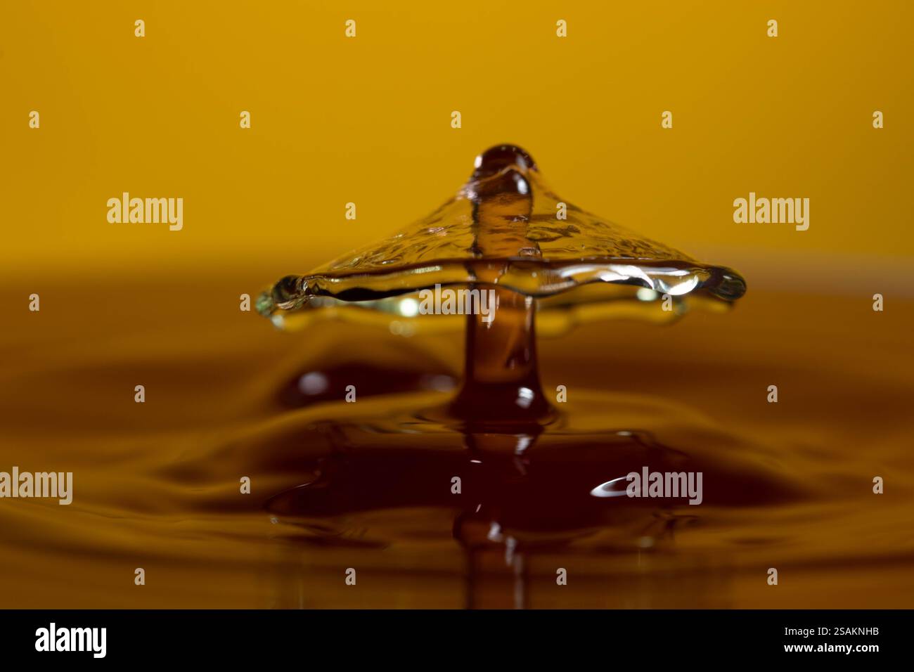 Splashart water collision on yellow background Stock Photo