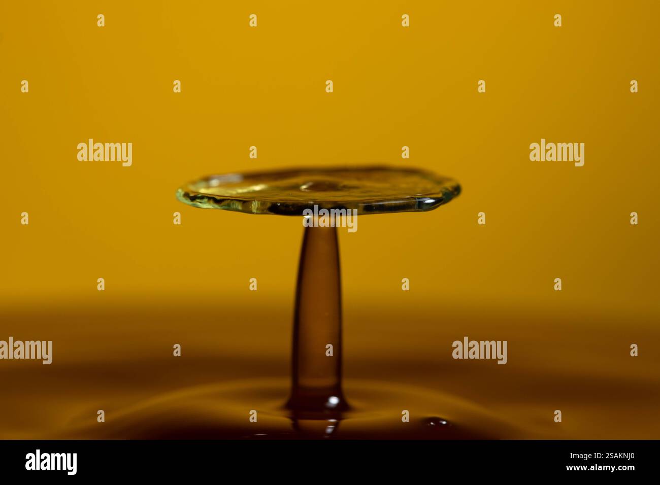 Splashart water collision on yellow background Stock Photo