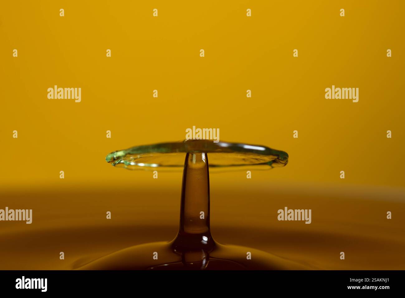Splashart water collision on yellow background Stock Photo