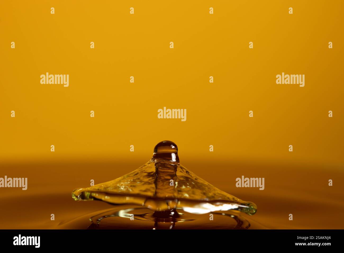 Splashart water collision on yellow background Stock Photo