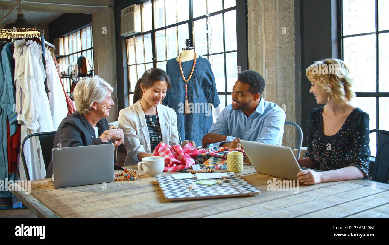 Male And Female Fashion Designers In Studio Meeting Discussing Fabric ...