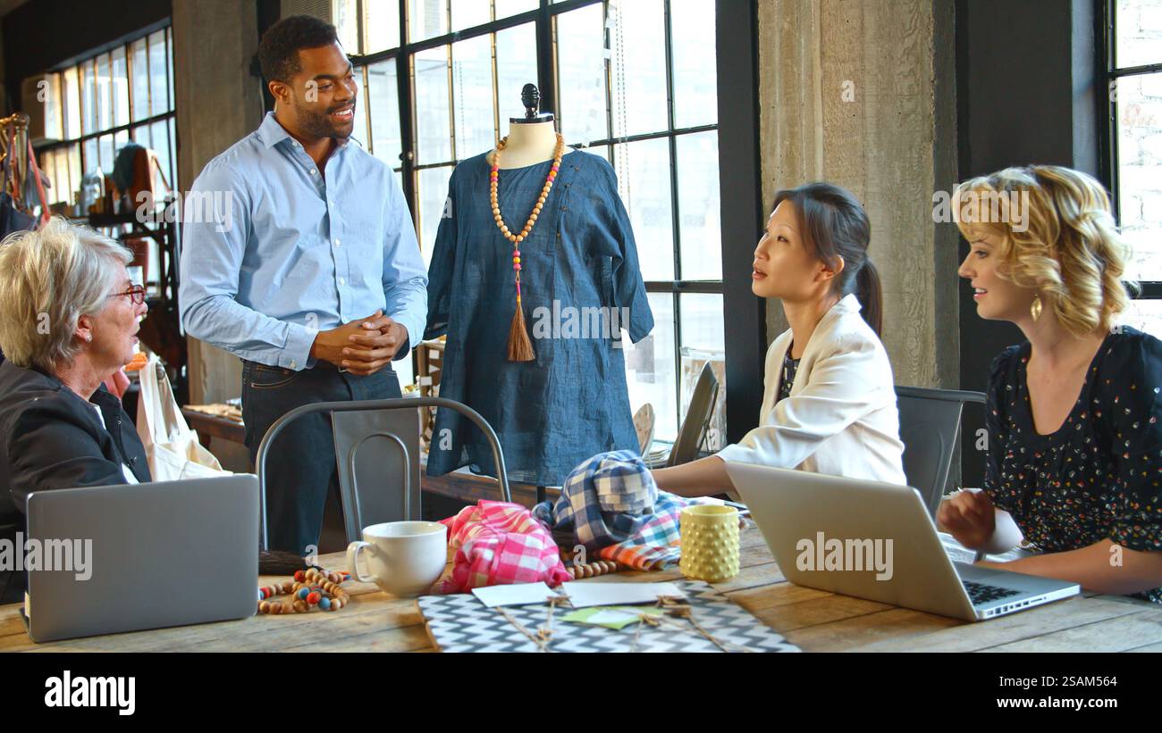 Male And Female Fashion Designers In Studio Meeting Discussing Garment ...