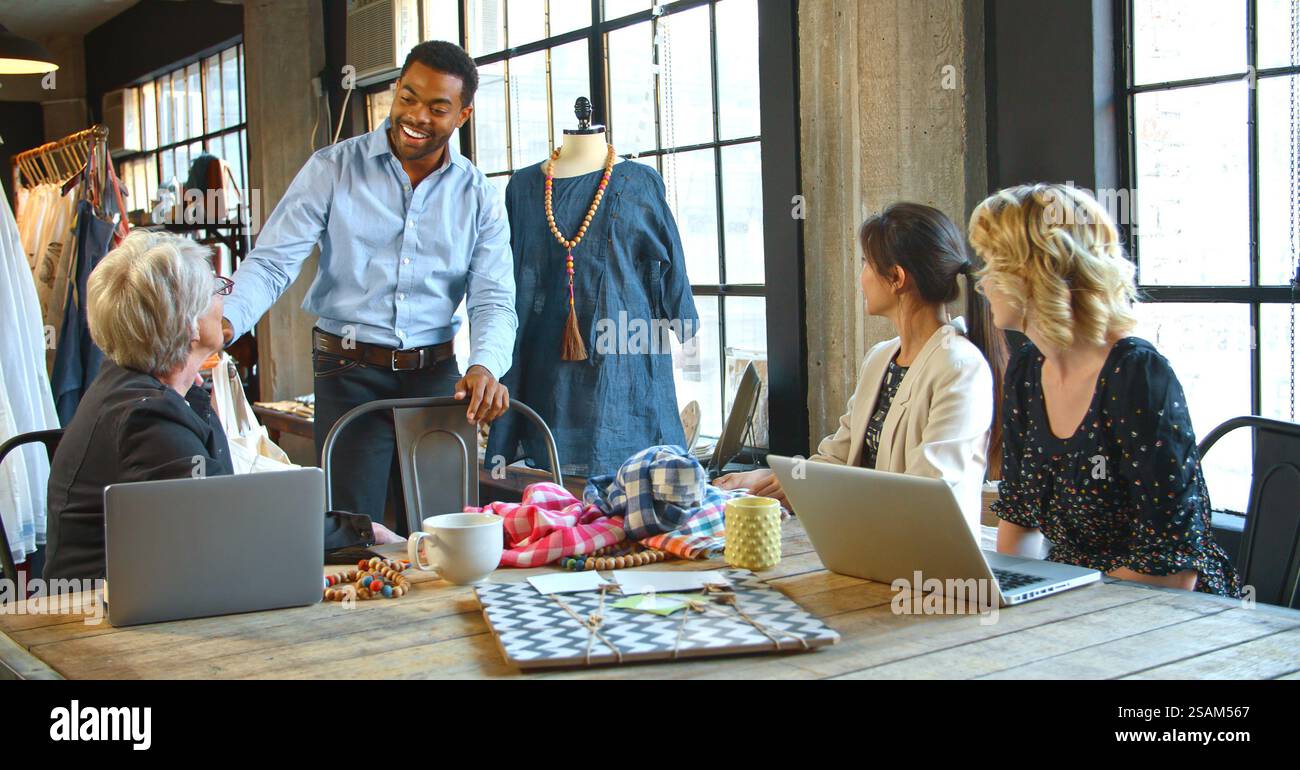 Male And Female Fashion Designers In Studio Meeting Discussing Garment ...