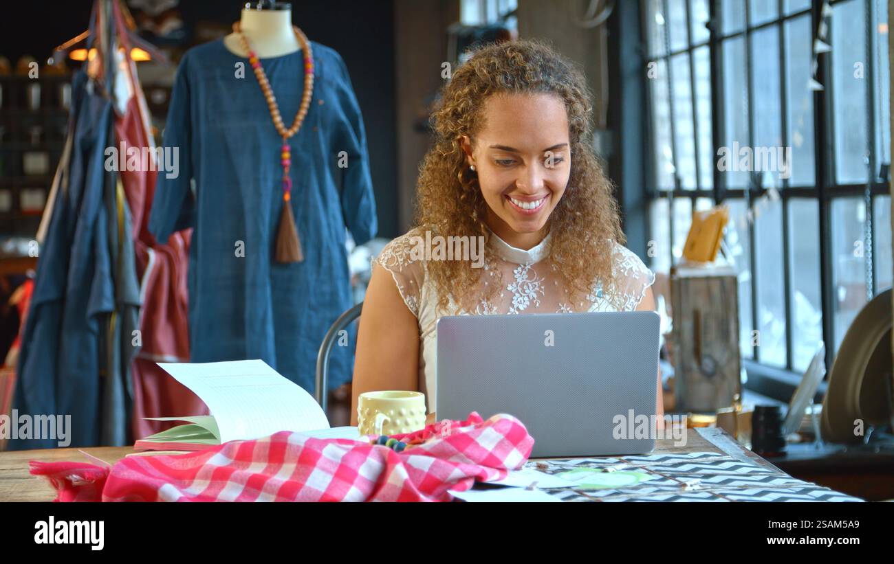 Young Female Fashion Designer In Studio Sitting At Desk Working On ...