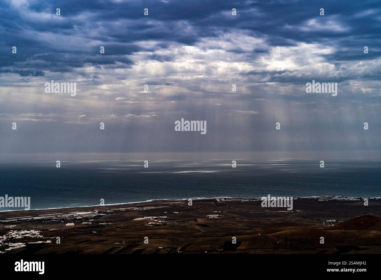 A dramatic sky with dark clouds and rays of sunlight breaking through ...