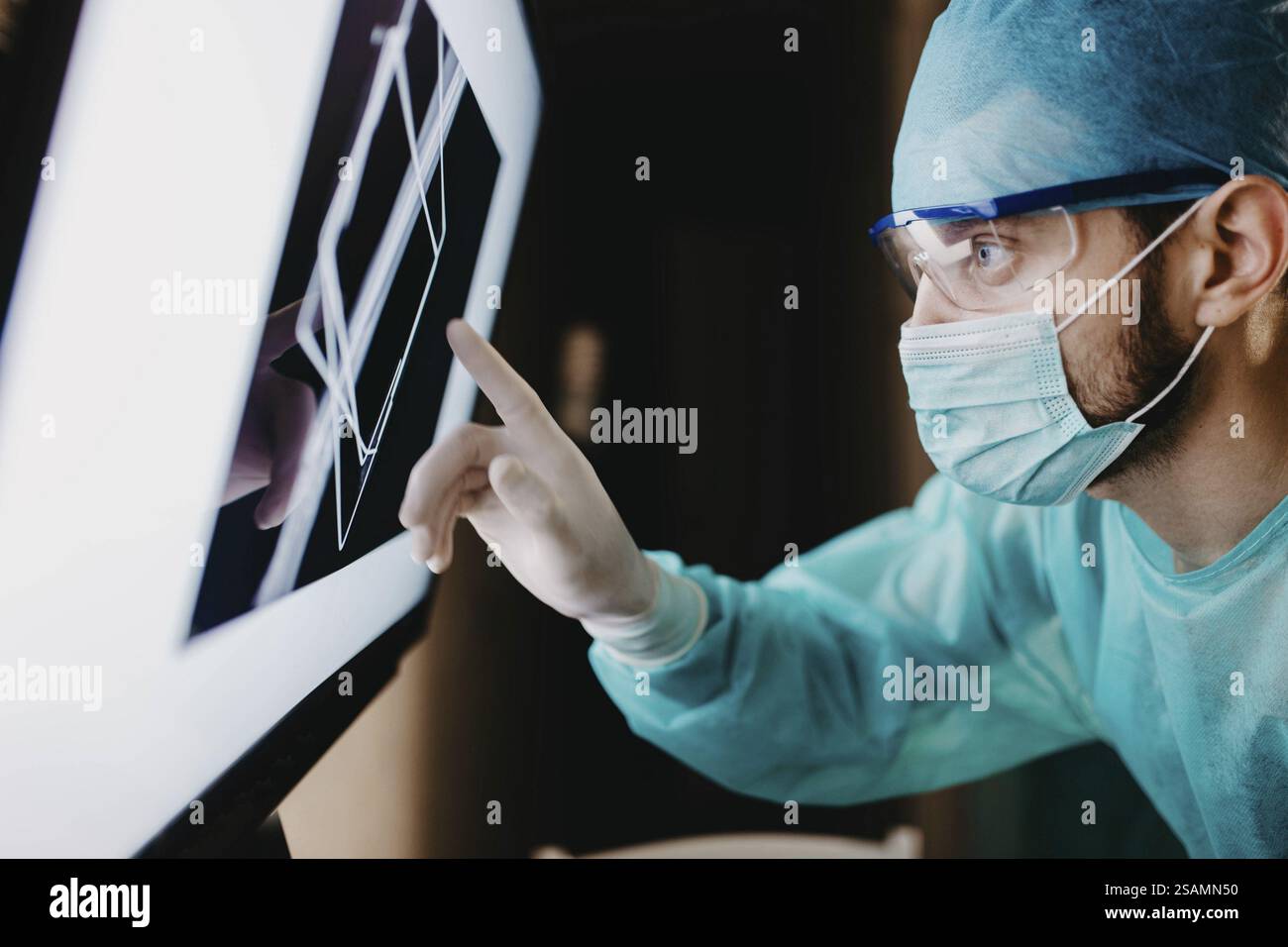 A surgeon analyzing data on a touch screen with concentration Stock ...
