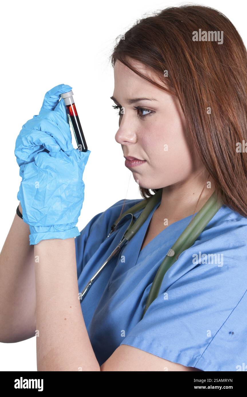 A beautiful young female doctor holding a test tube vial sample of ...