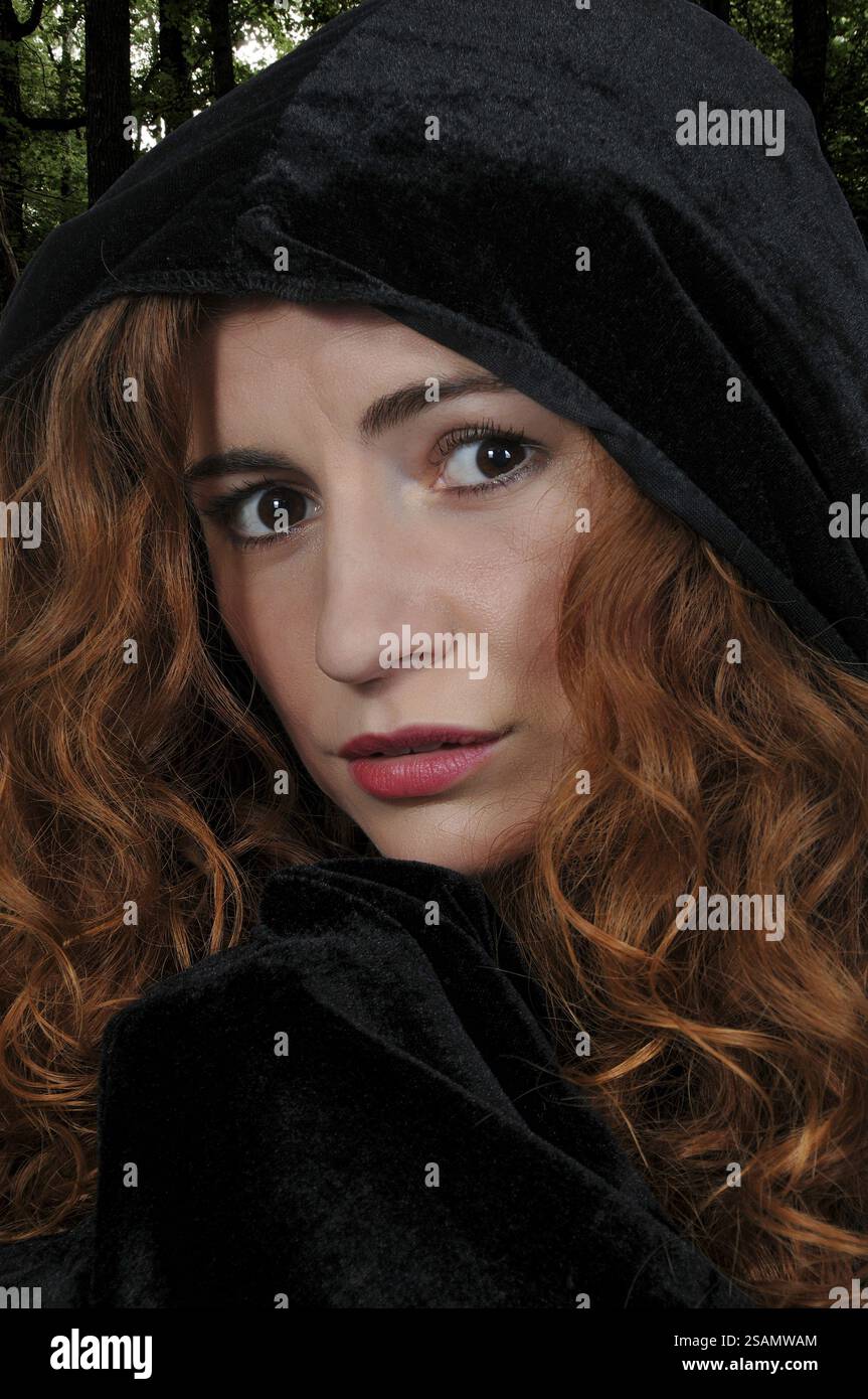 Beautiful woman wearing a long black cloak Stock Photo - Alamy