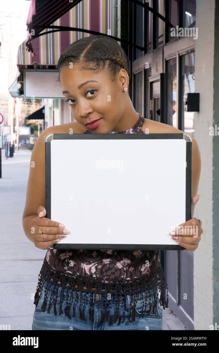 Beautiful young woman holding up a blank sign Stock Photo - Alamy