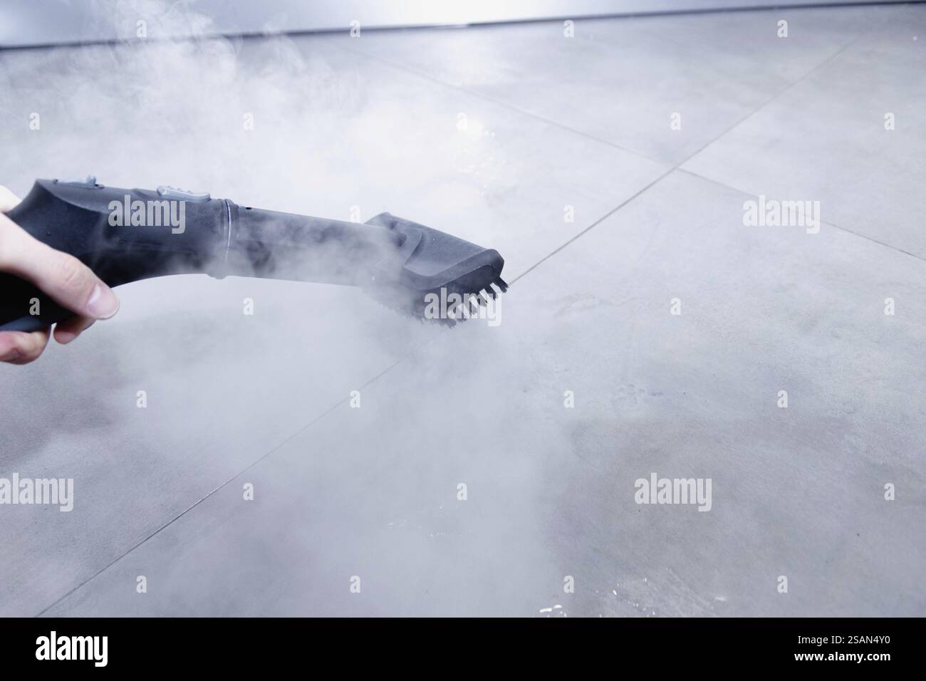 Steam cleaner emitting vapor over a gray, pristine floor Stock Photo ...