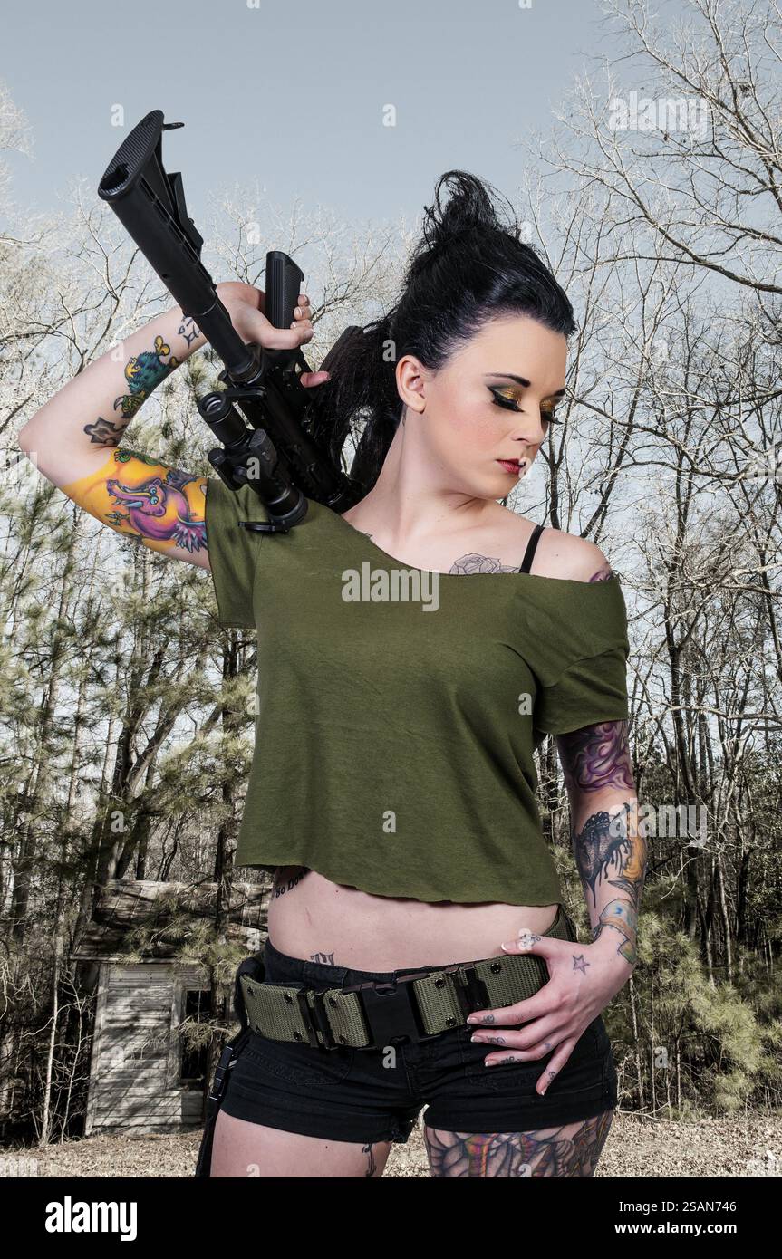 Beautiful young woman holding an automatic assault rifle Stock Photo ...