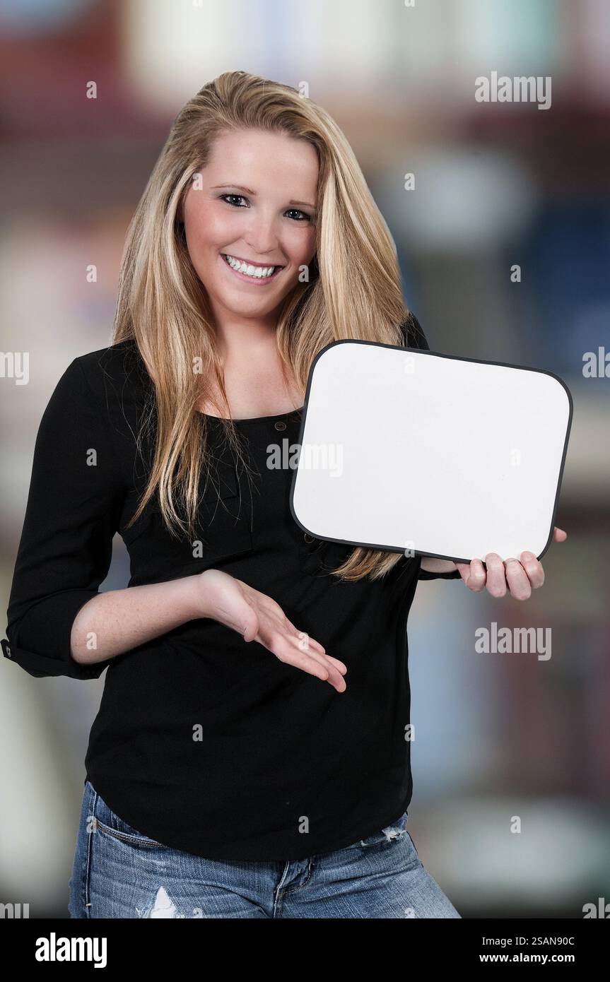 Beautiful young woman holding up a blank sign Stock Photo - Alamy
