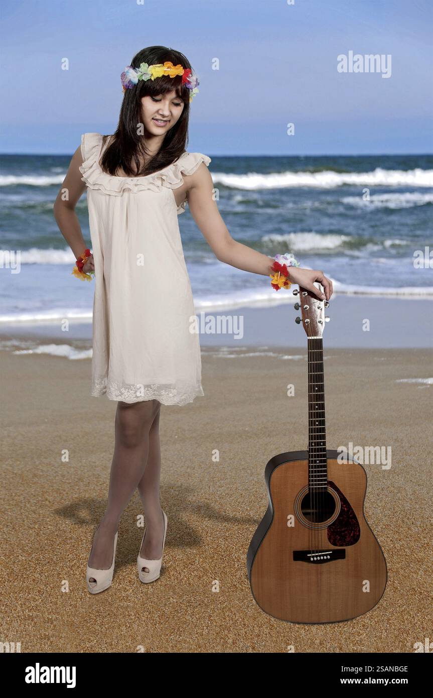 Beautiful young woman playing an acoustic guitar Stock Photo - Alamy