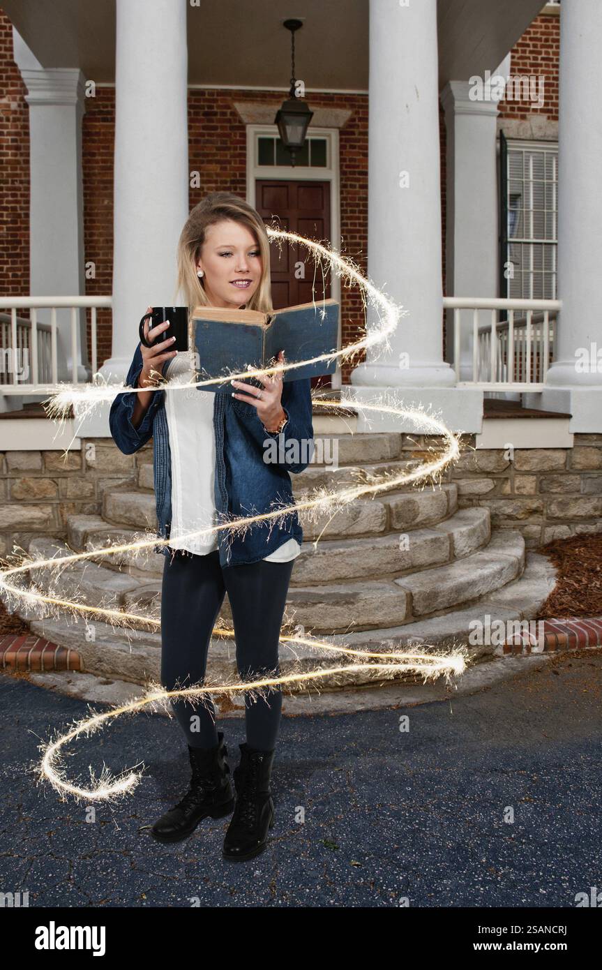 Beautiful woman reading a book while drinking a hot beverage Stock Photo