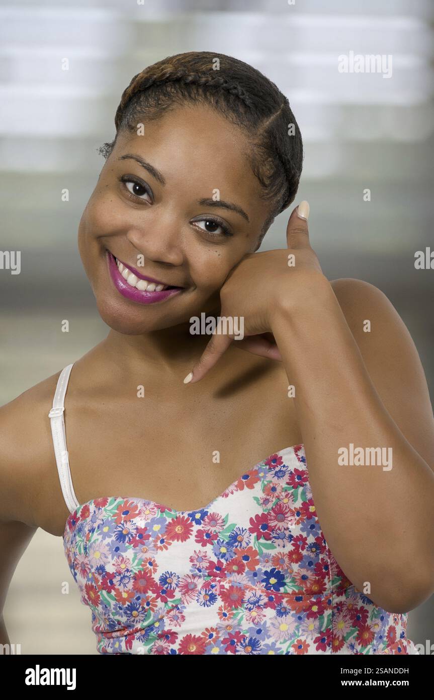 Woman using finger sign to ask someone to call her Stock Photo - Alamy