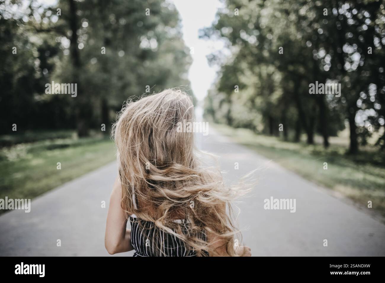 Woman walks along sun drenched hi-res stock photography and images - Alamy