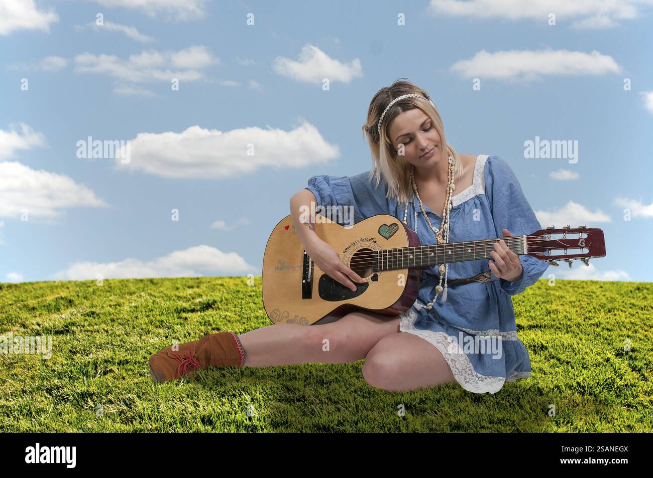 Beautiful young woman playing an acoustic guitar Stock Photo - Alamy