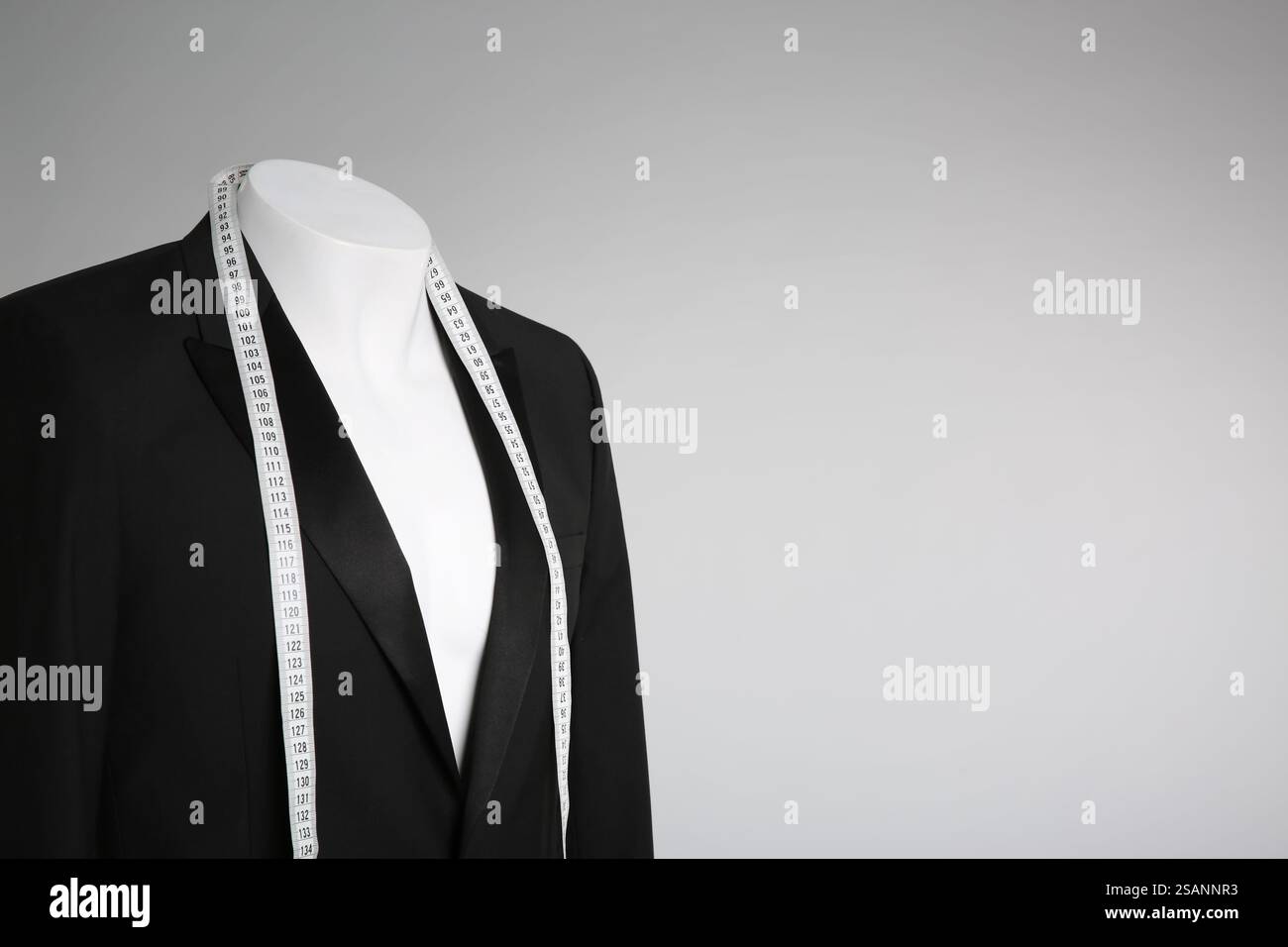 Male mannequin with elegant suit jacket and measuring tape on grey ...