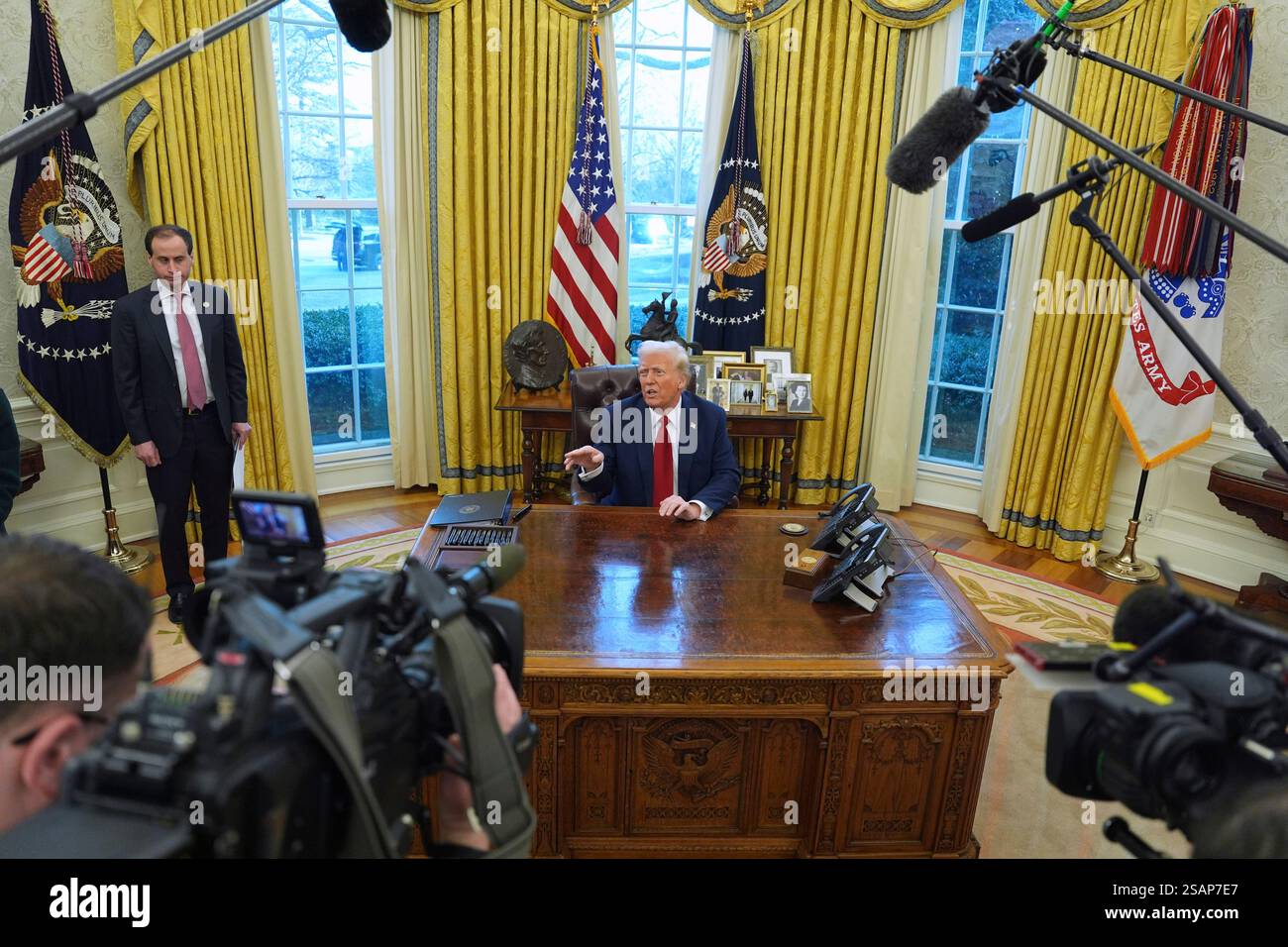 President Donald Trump talks with reporters as he signs executive