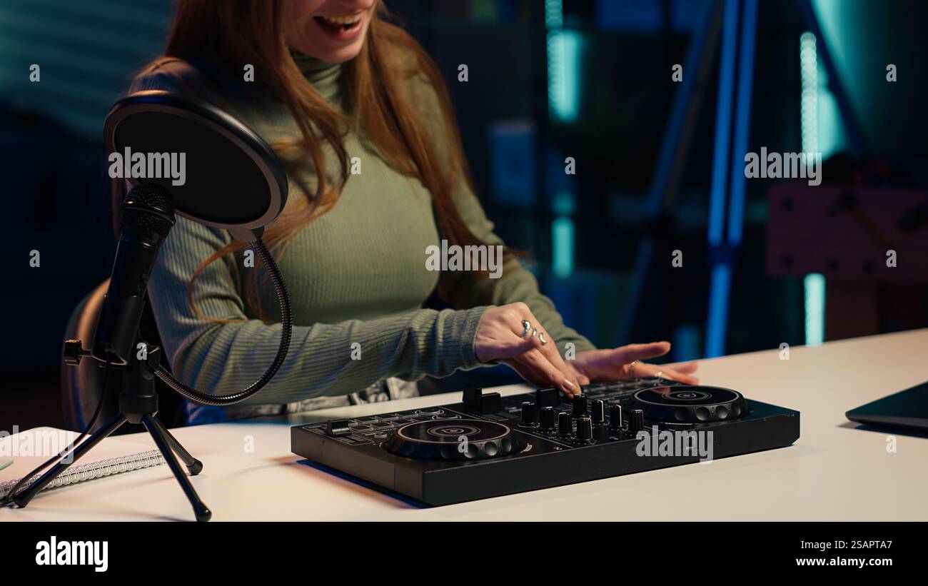 Young artist films DJ mixing tutorial in apartment studio, showing ...