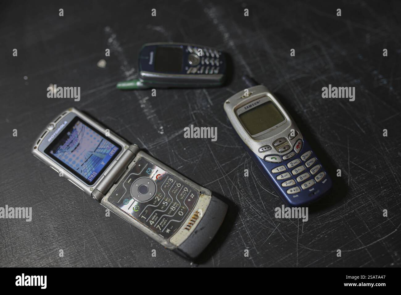 Three retro mobile phones presented on a black textured surface Stock Photo